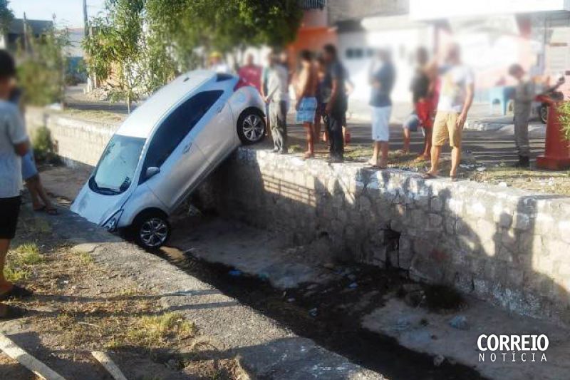 Carro cai dentro de canal após motorista perder controle da direção ao tirá-lo da garagem